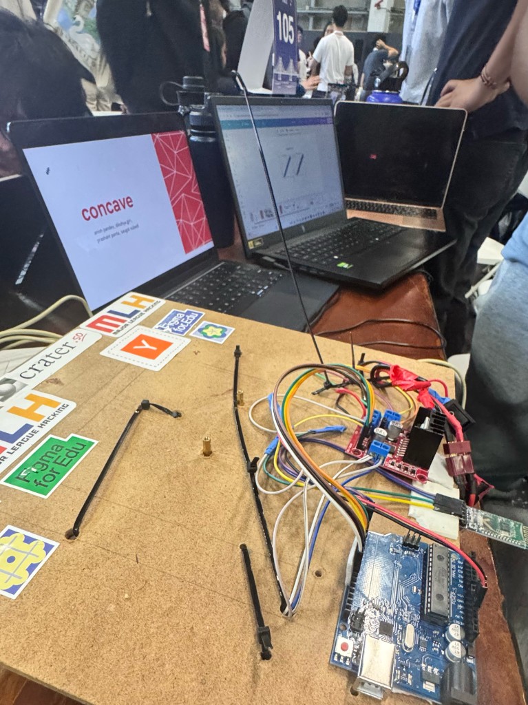 Concave hackathon demo with laptops, Arduino board, and wiring at Calhacks'25